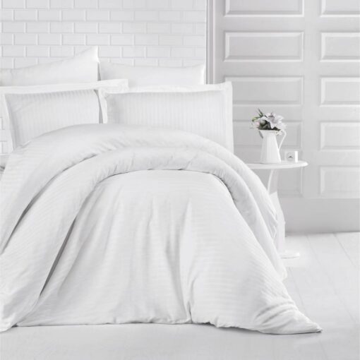 queen bed with white stripe bed sheet and comforter on the bed adding a nice touch to the white room, stripe bed sheets and comforter set with four pillows