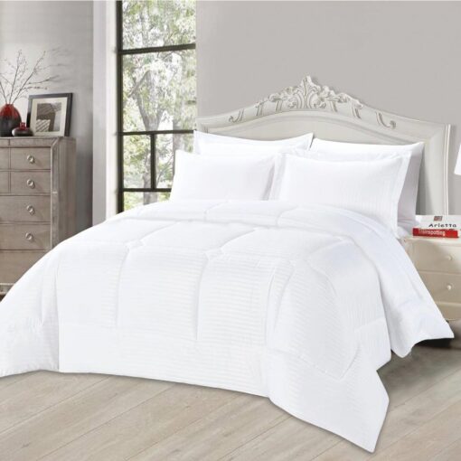 White striped comforter set with matching pillow shams on a king-sized bed in a stylish bedroom featuring a white headboard and large window