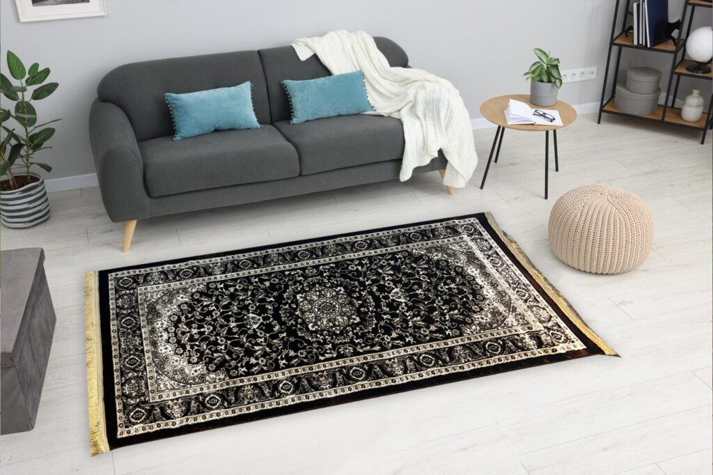 A stylish living room featuring a plush black and gold patterned carpet with intricate details, complemented by a modern grey sofa, teal accent pillows, a cozy throw blanket, and minimalistic