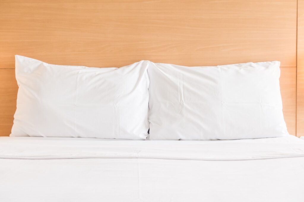 two pillows on white mattress